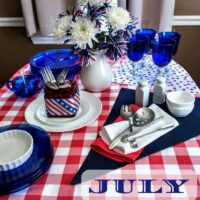 july table scape red and white tablecloth and cobalt blue dishes