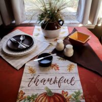 november table setting titled thankful dark orange tablecloth runner of fall colors on ivory and brown and tan dishes