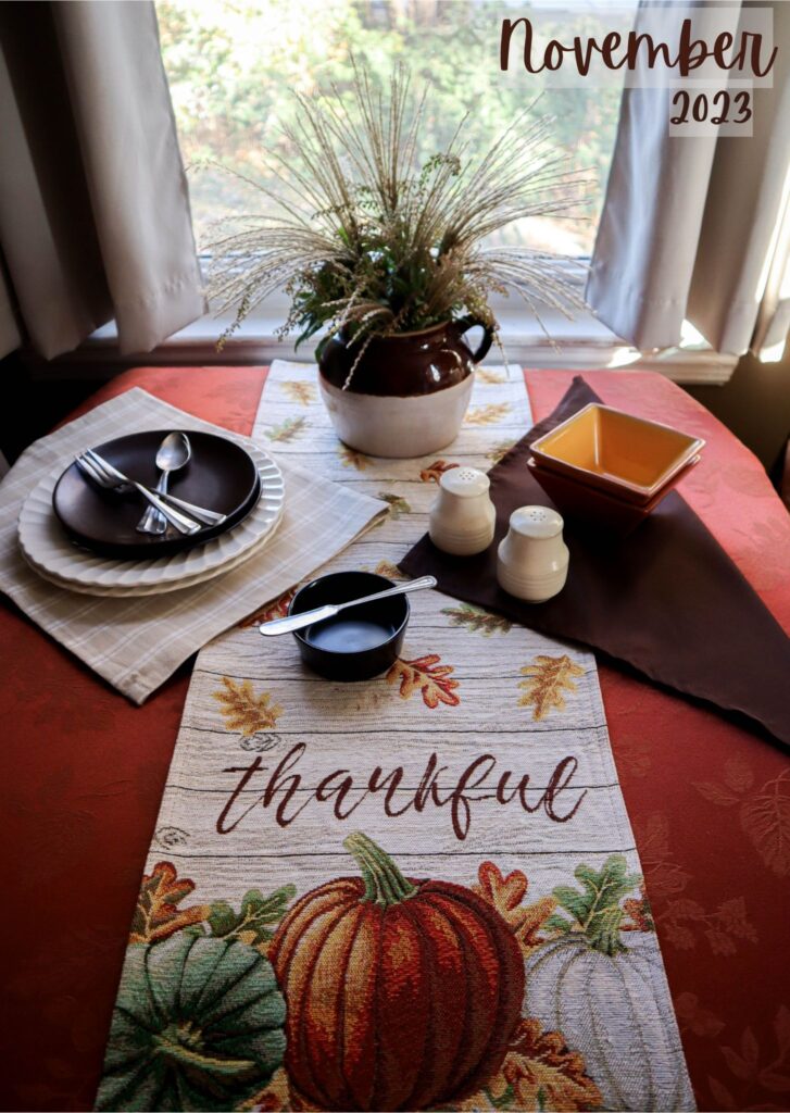 november table setting titled thankful dark orange tablecloth runner of fall colors on ivory and brown and tan dishes