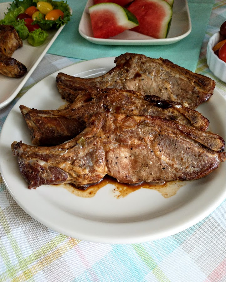 country style ribs marinated and served on a platter watermelon and grape tomatoes on table