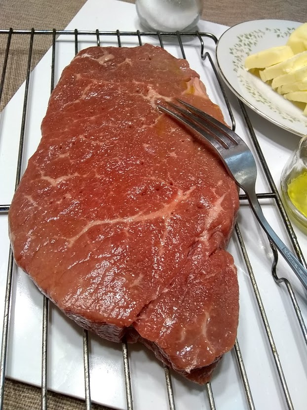 london broil steak pierced and rubbed with olive oil and salt