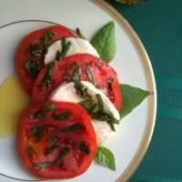 caprese salad served on ivory and gold plate