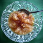 Cut glass dish with homemade applesauce topped with maple syrup and nutmeg