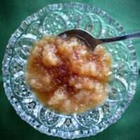 Cut glass dish with homemade applesauce topped with maple syrup and nutmeg
