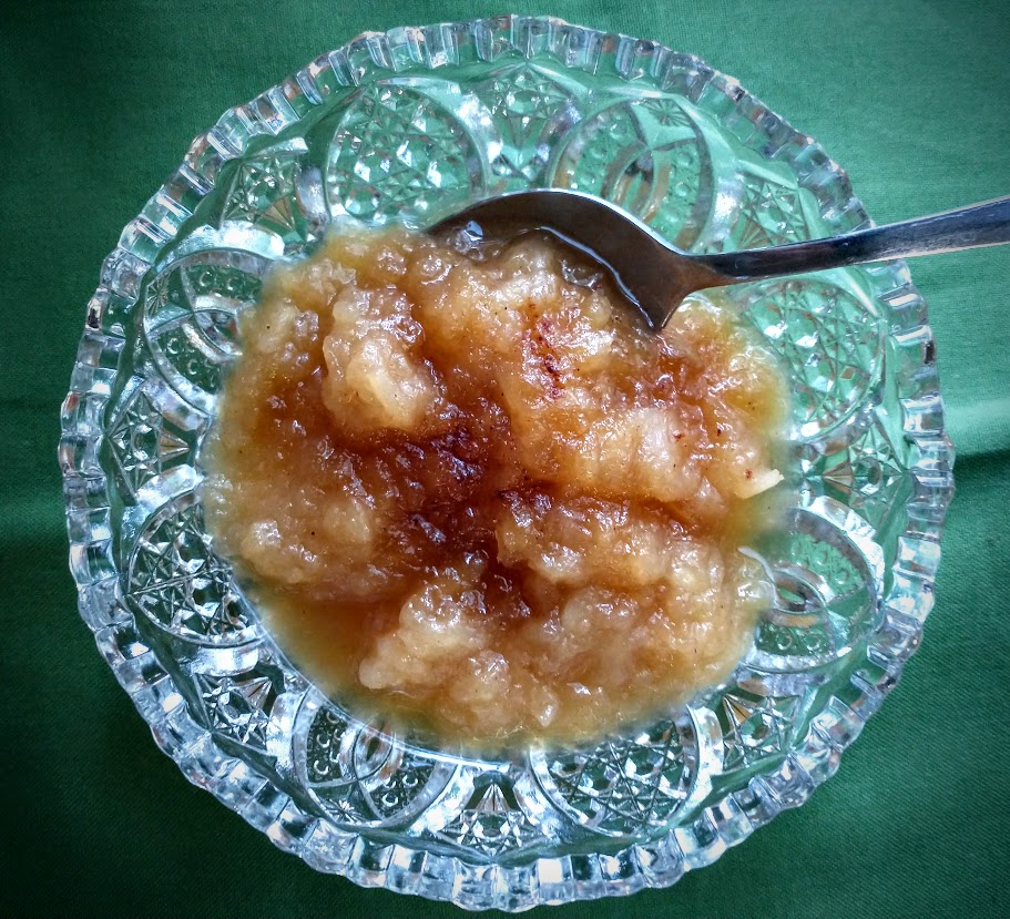 Cut glass dish with homemade applesauce topped with maple syrup and nutmeg