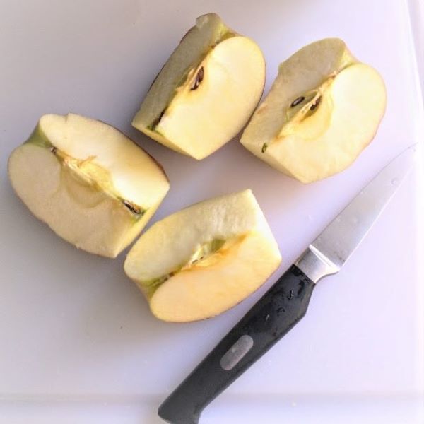 apple quartered with a paring knife