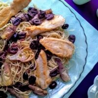 kalamata olives and artichoke hearts served over pasta with chicken tenders on top served in a large serving platter