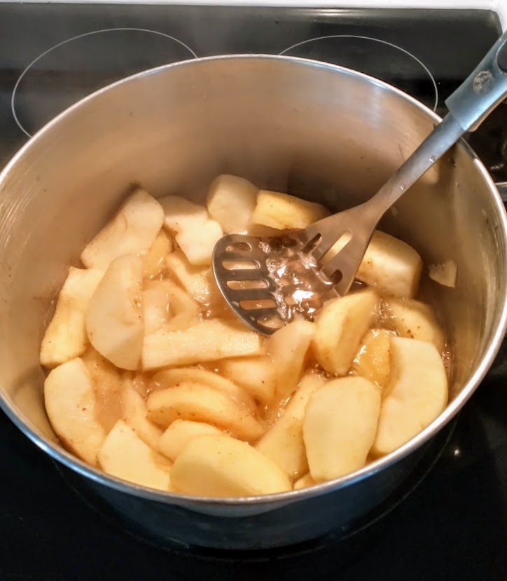 mashing cooked apple slices