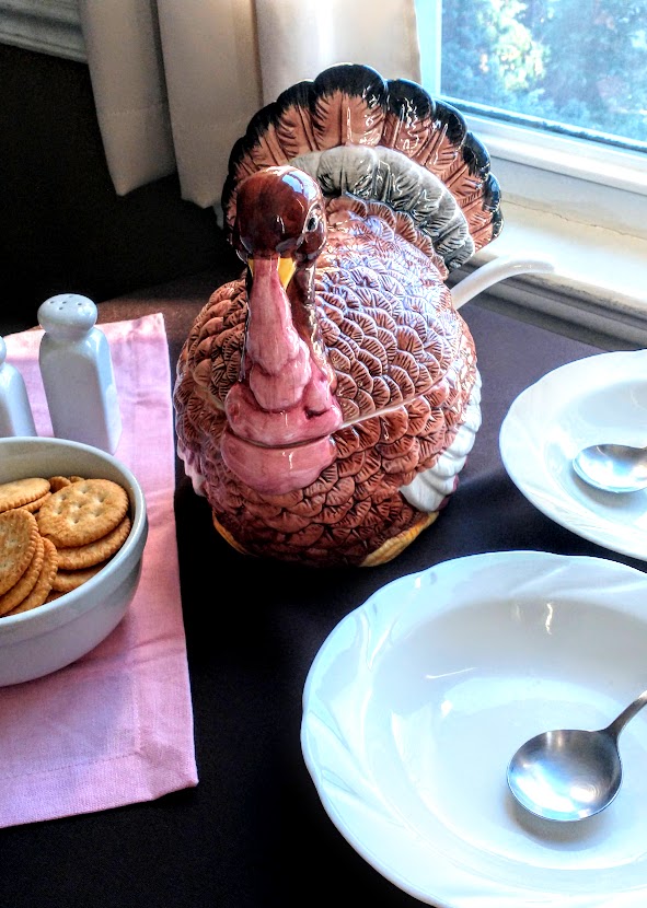 turkey soup tureen on table with bowls and crackers