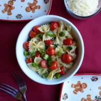 kids meal with tomato green onion and bowtie pasta in a bowl on the table