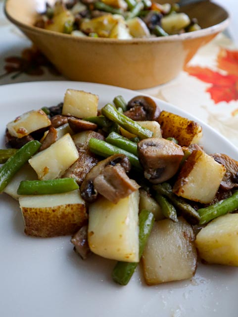 potato mushroom and green ben saute served on a plate as a side dish