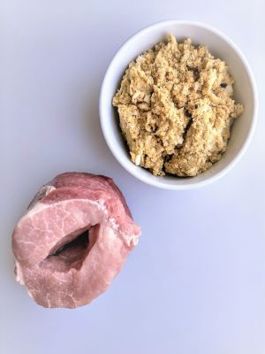 small bowl of stuffing and pork loin roast with cut through the middle