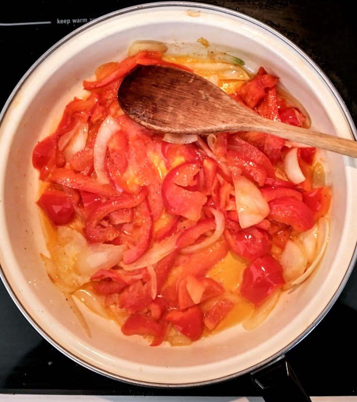 red pepper and onion sautéing in a skillet with olive oil