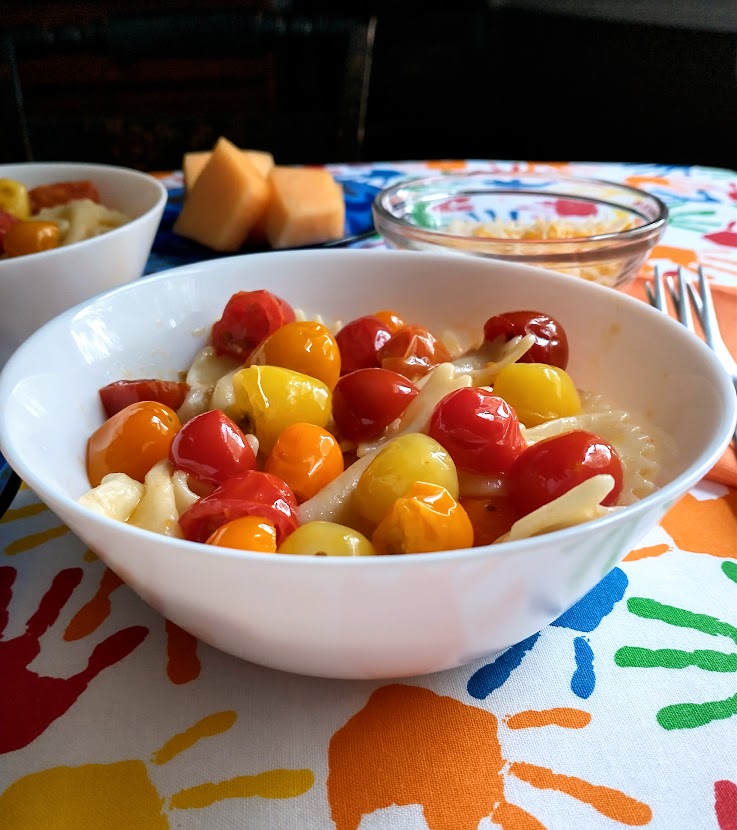 kids pasta meal with colored grape tomatoes in white bowl