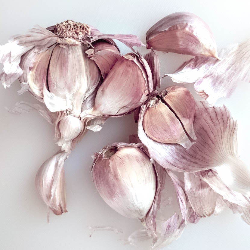 a head of garlic broken open to show the cloves
