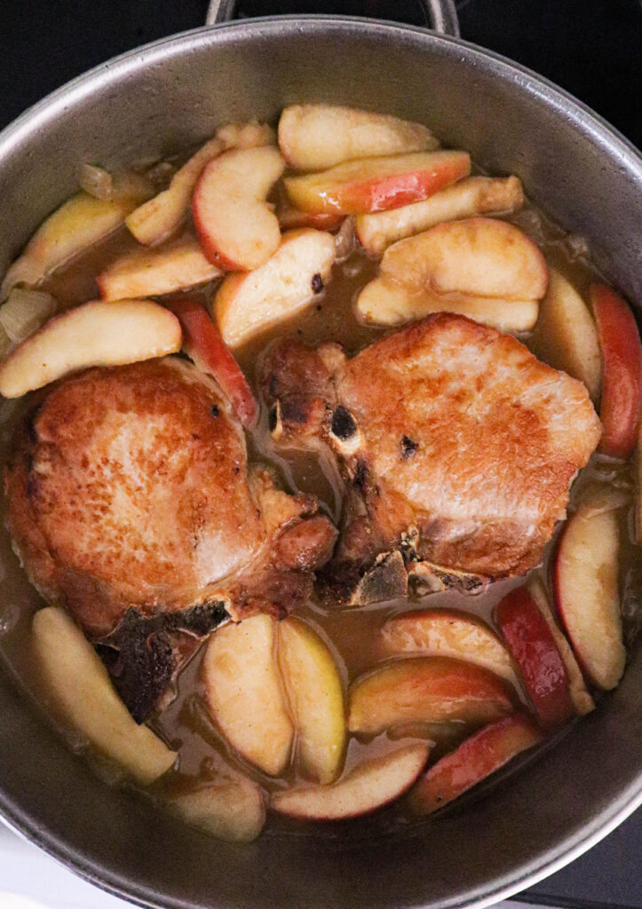 pork chops added to apples onions and cider sauce