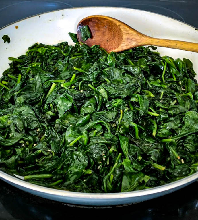 spinach leaves wilted down in skillet