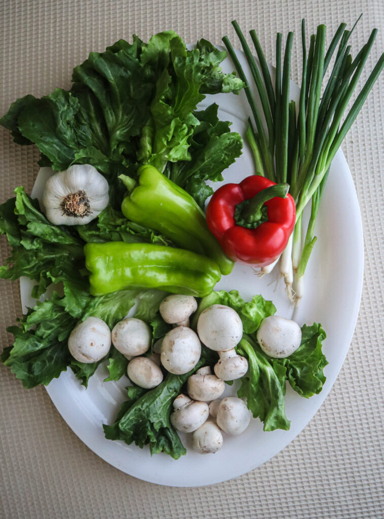 ingredients for veggie wrap mix escarole red pepper cubanelle peppers scallions mushrooms garlic uncut on platter