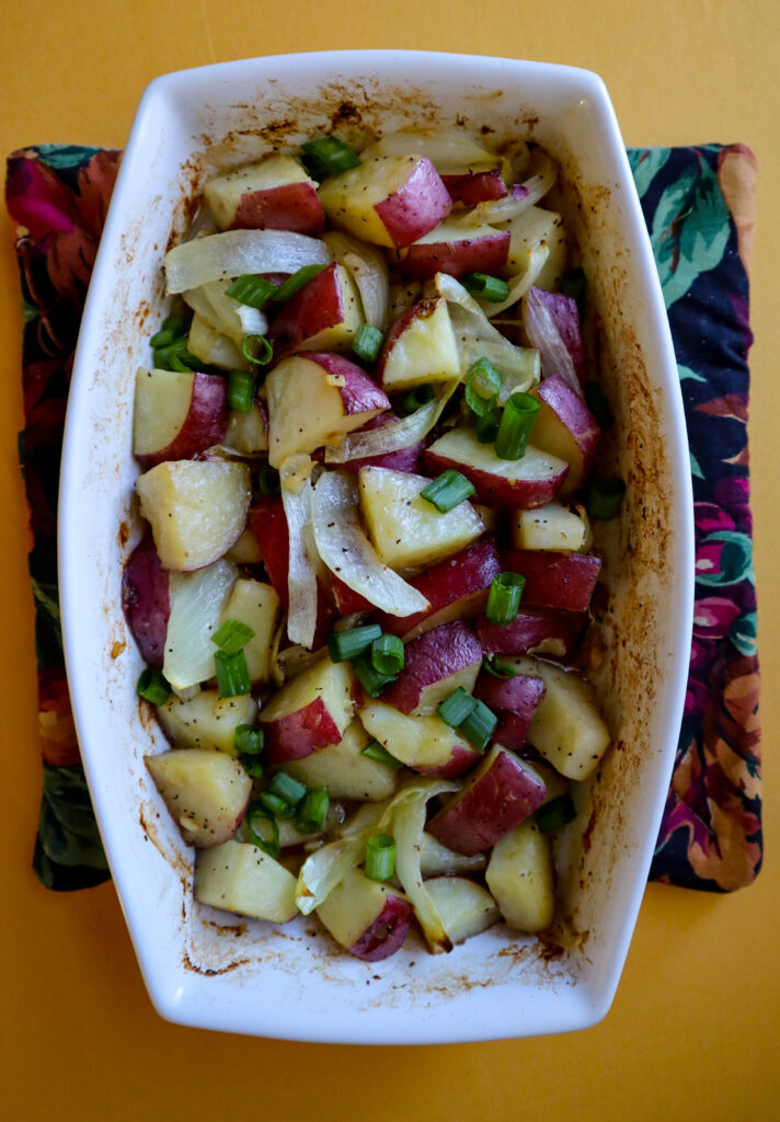 potato and onion in a garlic butter sauce fully cooked in a baking dish