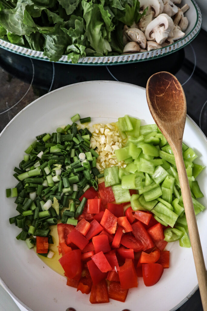 vegetable saute ingredients added to the skillet with olive oil