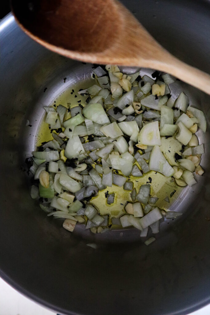 olive oil garlic onion and basil in stockpot on stove