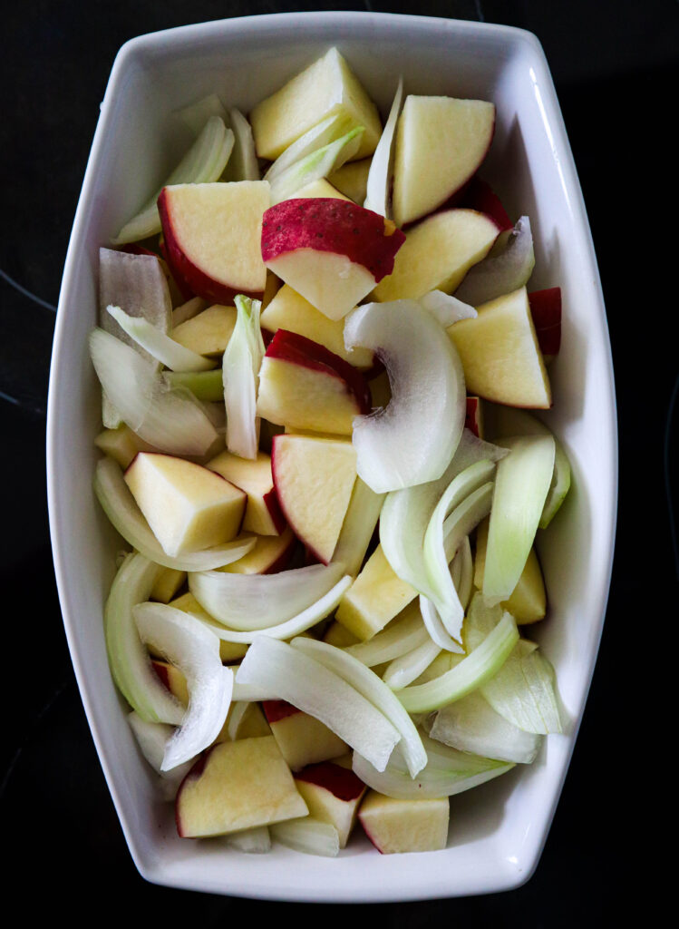 chopped red potatoes and sliced onions in a baking dish