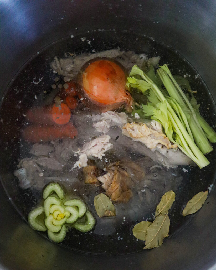 bones and vegetables with spices in the water ready to cook