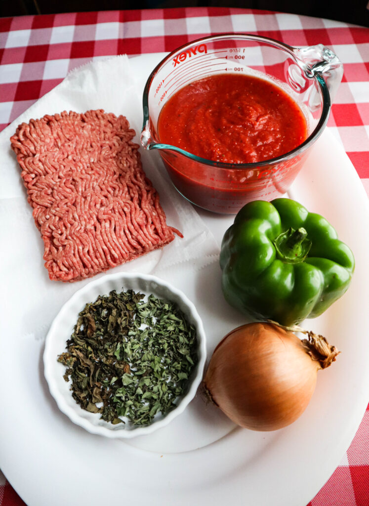 ingredients for american chop suey hamburg crushed tomato green pepper onion basil and oregano