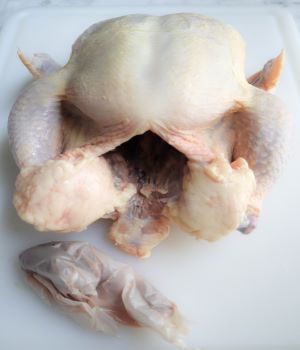 whole raw chicken with cavity open and neck taken out