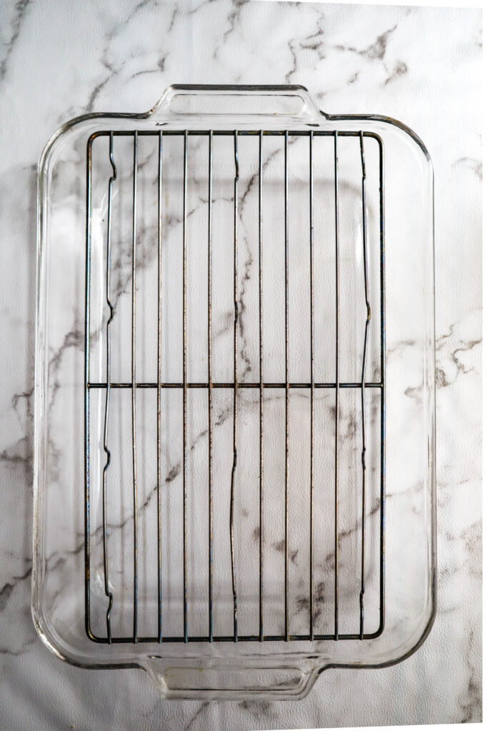 a glass baking dish with a bakers rack placed in it for raosting