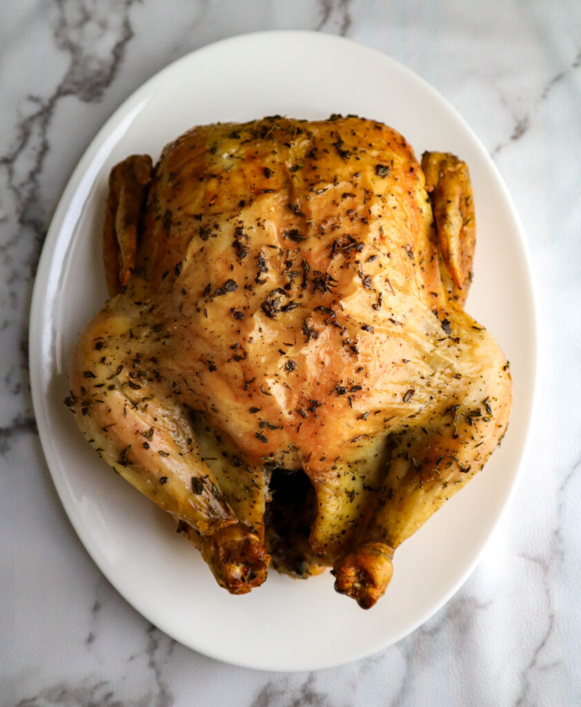 whole roasted chicken with herbs out of the oven