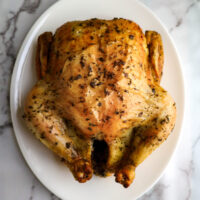 whole roasted chicken with herbs out of the oven
