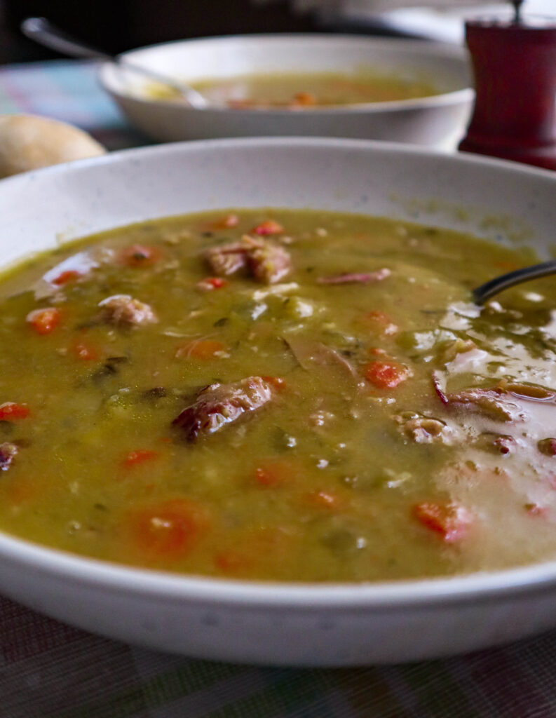 split pea soup with carrots celery and ham served in a large bowl