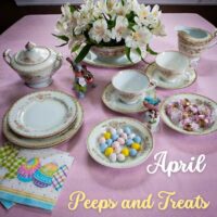 april dinner table set up with candy flowered plates and a ceramic piece with robins on a tree branch