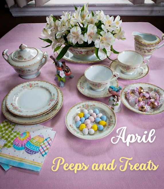 april dinner table set up with candy flowered plates and a ceramic piece with robins on a tree branch