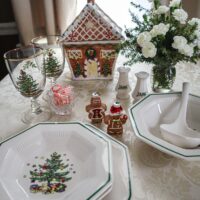 december dinner table with 2 glittered gingerbread characters walking through a wonderland of christmas tree plates