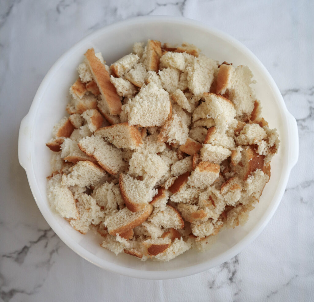 a large white bowl full of cubed white bread