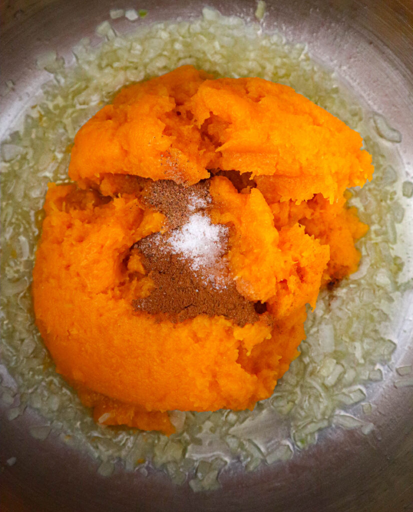 mashed squash and spices added to saucepan with butter and onion