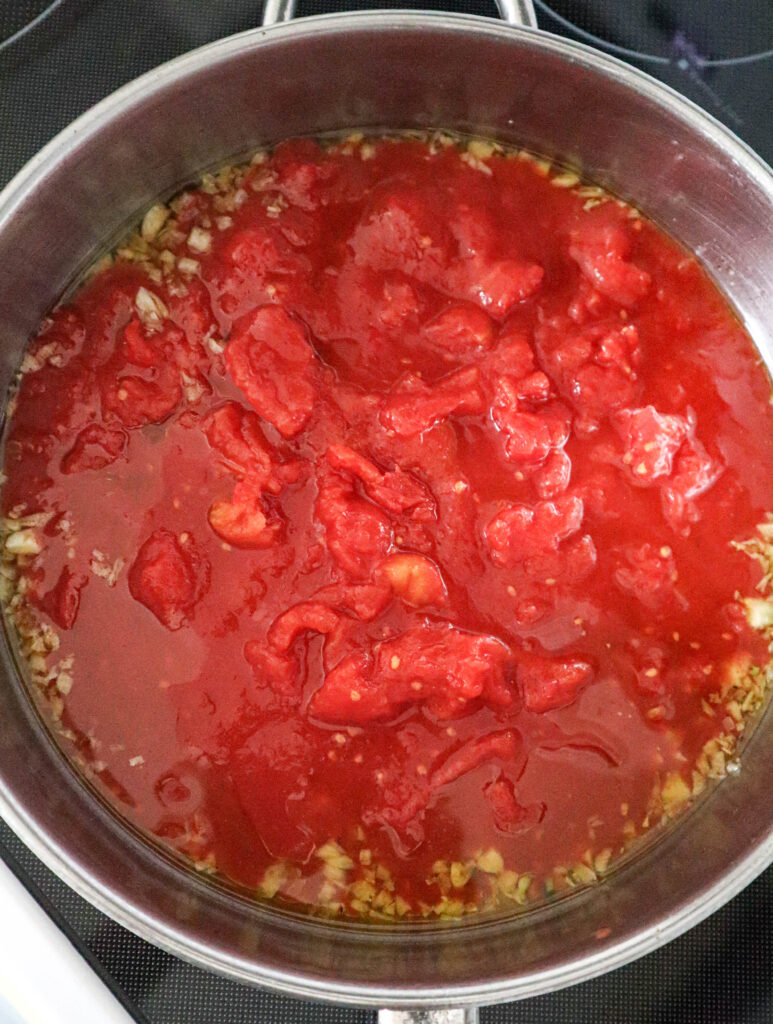 add crushed tomato to garlic and oil