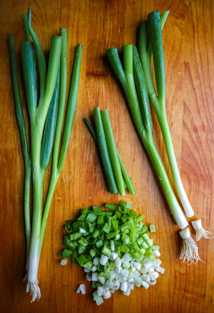 scallions on a cutting board whole and cut up