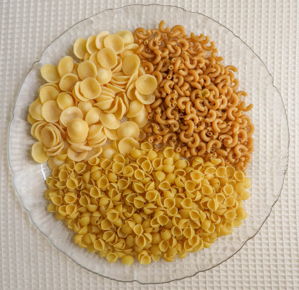 a plate with three kinds of uncooked pasta 