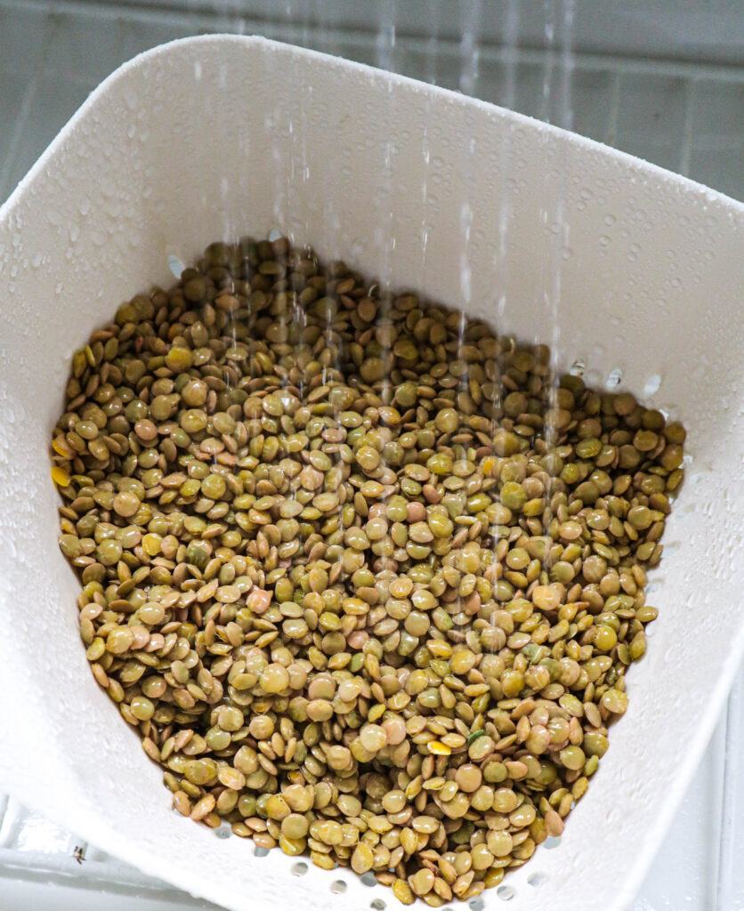 lentils being rinsed with running water