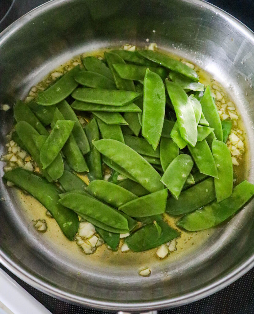 pea pods in a skillet with olive oil and garlic