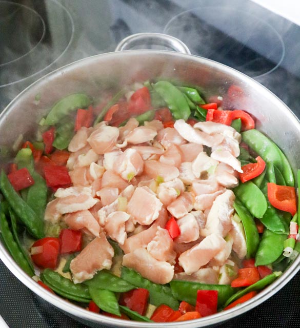 adding chopped chicken to the vegetables