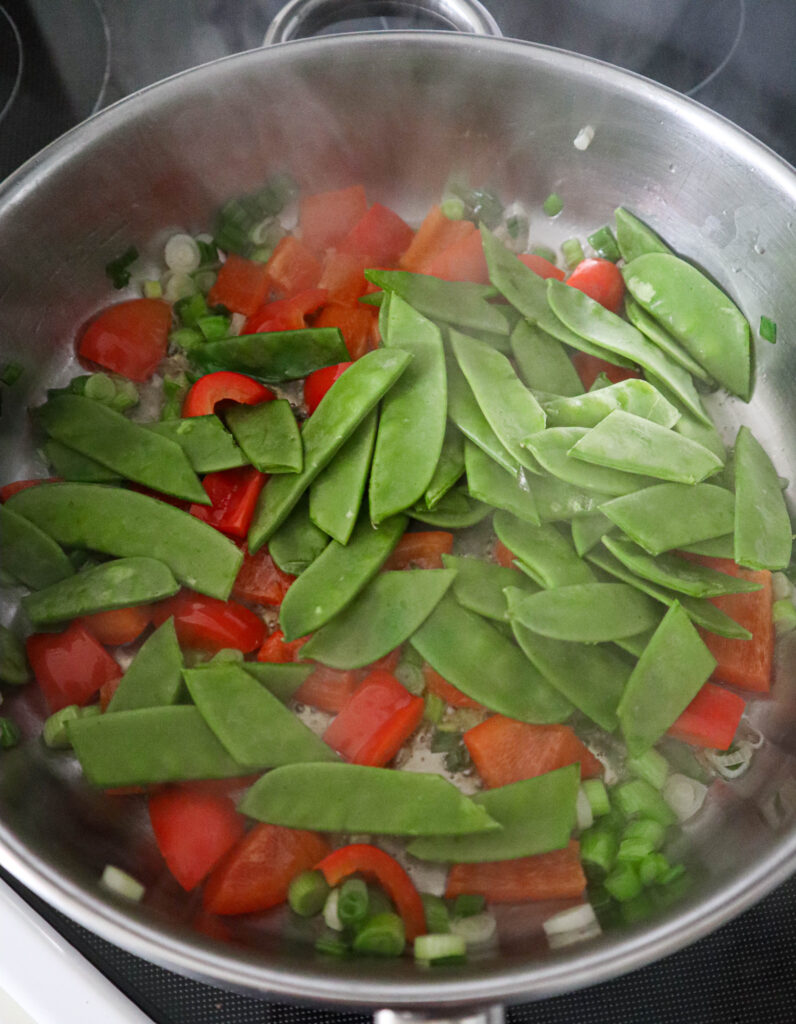 adding snow pea pods to the skillet