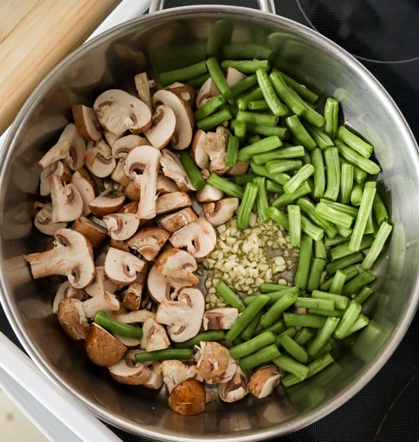 skillet with green beans mushrooms garlic and oil