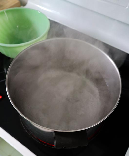 boiling water on the stove and a bowl in the picture