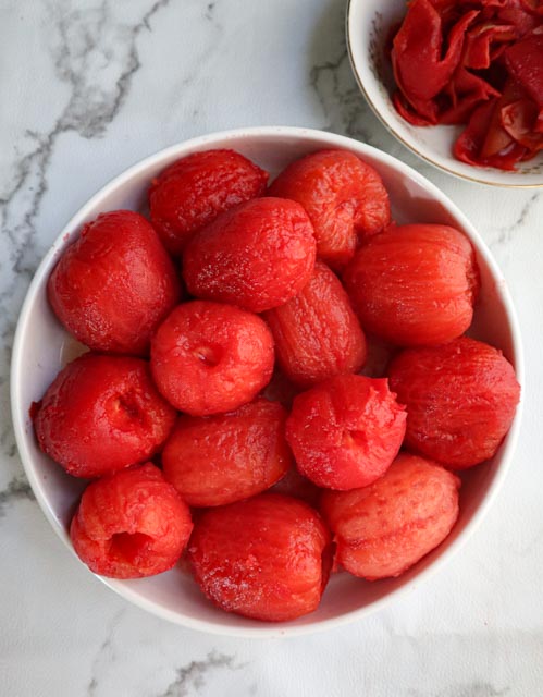 a bowl full of peeled plum tomatoes