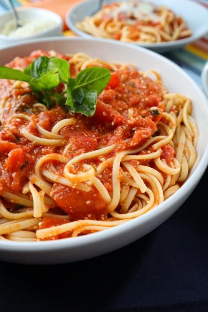 fresh tomato sauce over linguini served in a white bowl