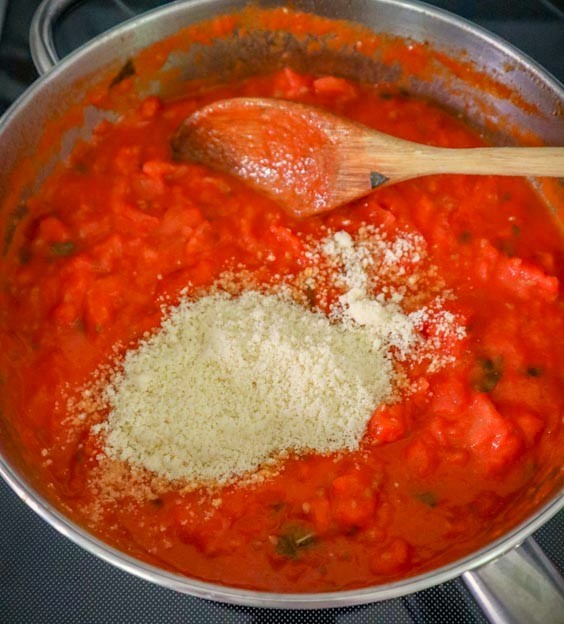 adding cheese to the fresh tomato sauce